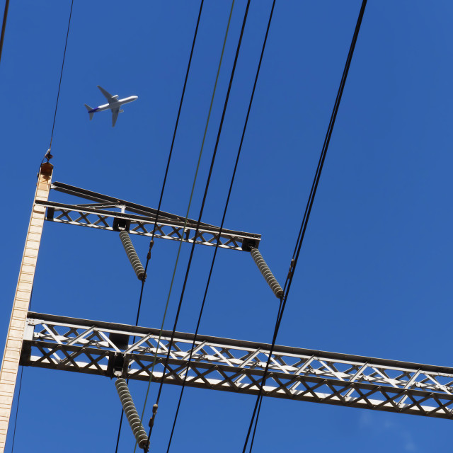 "Jet flying over the train station power lines" by JOHN MOUNT - $24.67 "Jet flying over the train station power lines" stock image