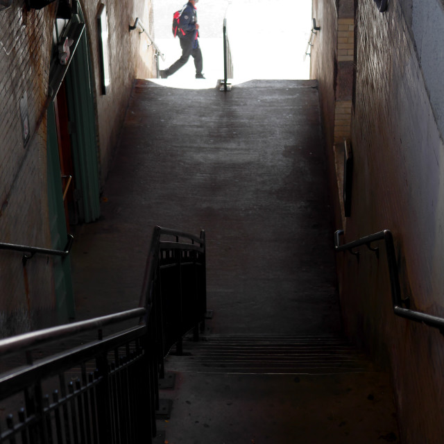 "Train station stairs with passing pedestrian" by JOHN MOUNT - $24.67 "Train station stairs with passing pedestrian" stock image