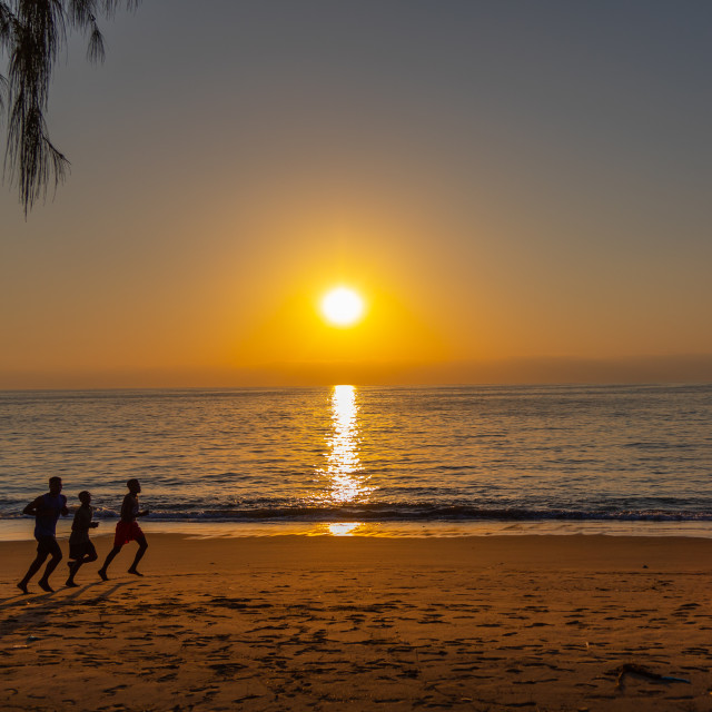 "Men running on the beach at sunset, Benguela Province, Benguela, Angola" stock image