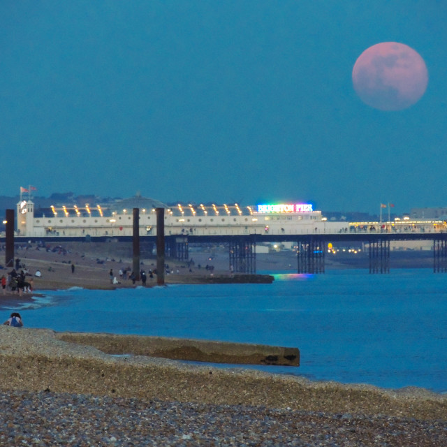 "Pink Full Moon Rising Over Brighton's Palace Pier" stock image