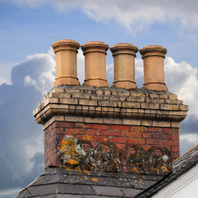 Chimneys on an old roof in Ivybridge, Devon, England, a typical row of ...