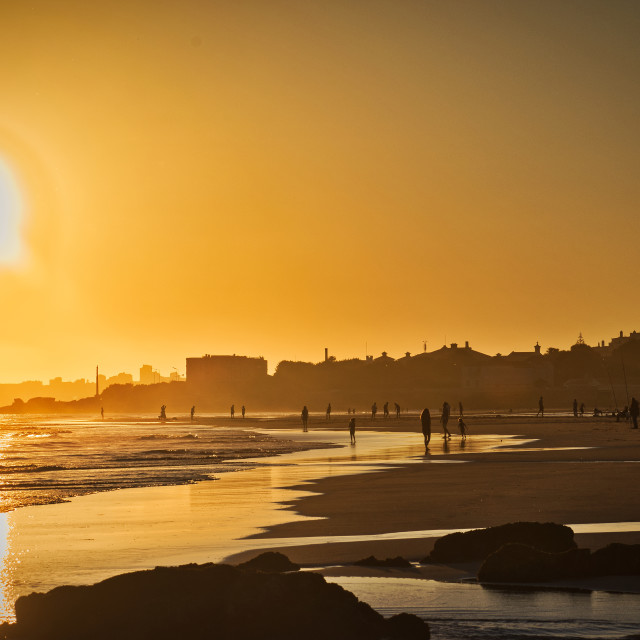 "Portugal Carcavelos Beach - People silhouettes at sunset on the beach in the golden hour" stock image