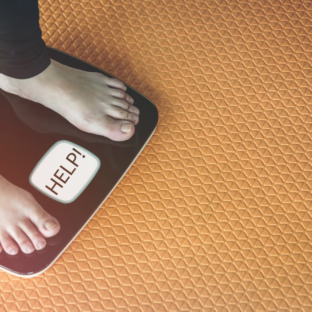 "An Asian woman's feet are on a scales." stock image