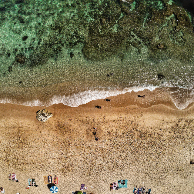 "AERIAL VIEW OF BEACH WATER AND PEOPLE ON THE SAND" stock image