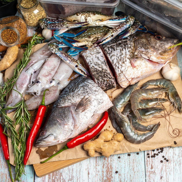 "Fresh Seafood - Golden Snapper, Sea Bass, Prawns, Crabs, and Squids - on a..." stock image