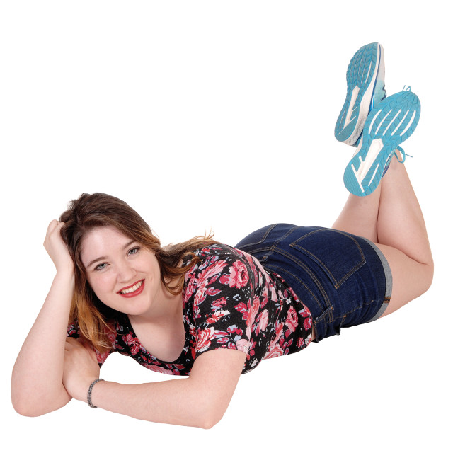 "Lovely young woman lying on her stomach on floor" stock image. 