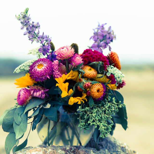 "Bouquet of Colorful Chrysanthemums, Eucalyptus, Green leaves, and Lavender Colored Wildflowers on a Beach" stock image