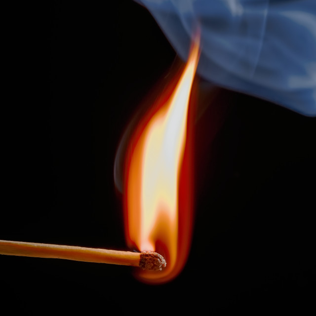 "Safety match on black background with flaming head" stock image