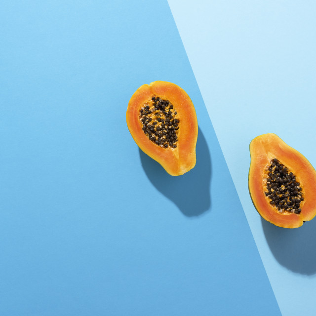 "Fresh papaya fruit cut in half on blue background. Tropical fruit" stock image