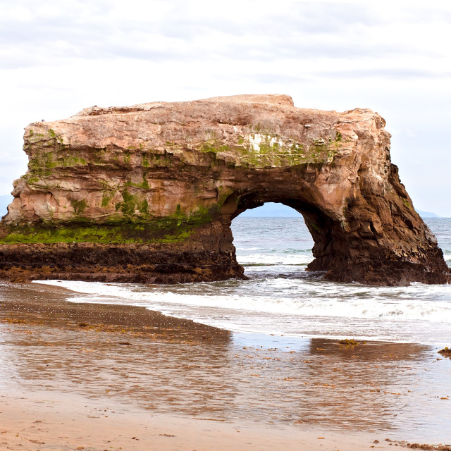 "Large Rock Tunnel Formation on a Sandy Beach in Santa Cruz, California" stock image