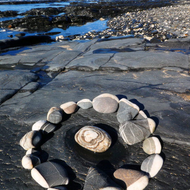 "pebble circle on a beach rock" stock image