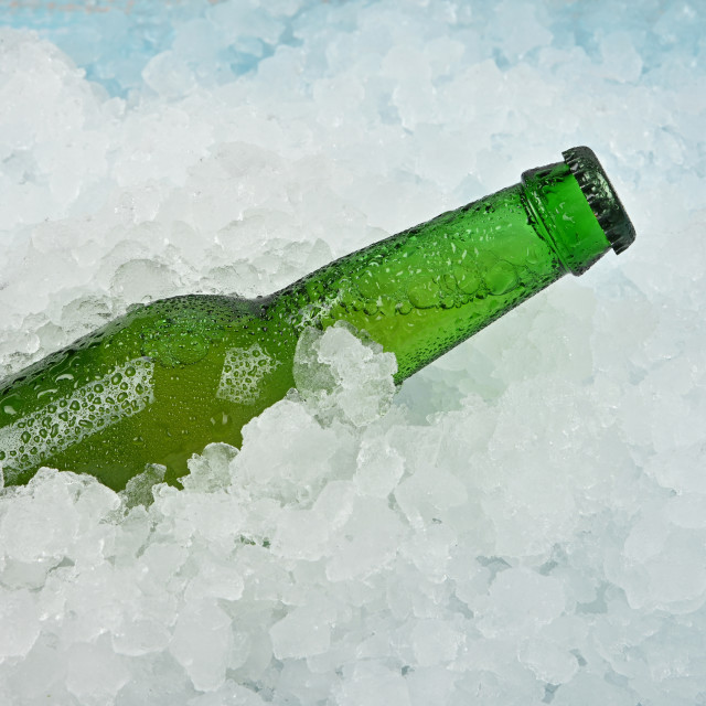 One bottle of cold lager beer on crushed ice.