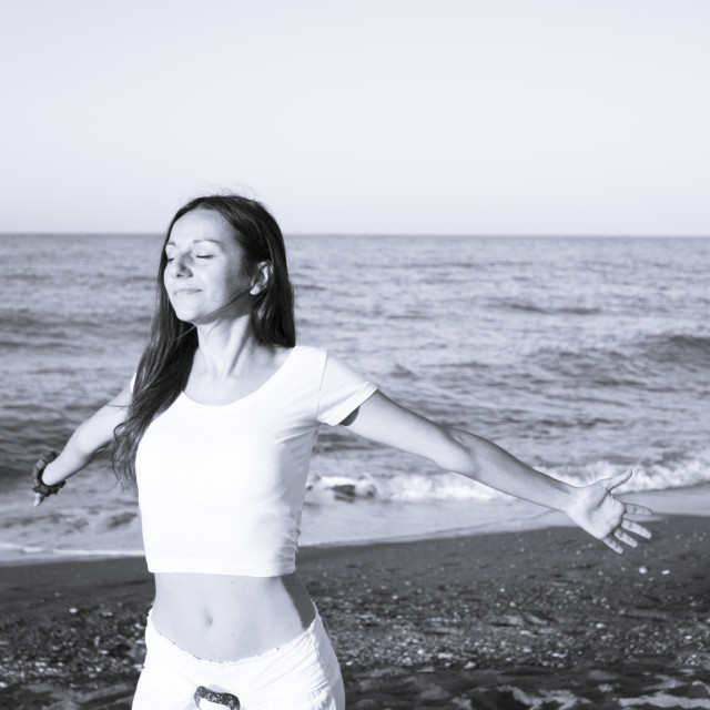 "Woman dressed in white barefoot on the beach sand" stock image