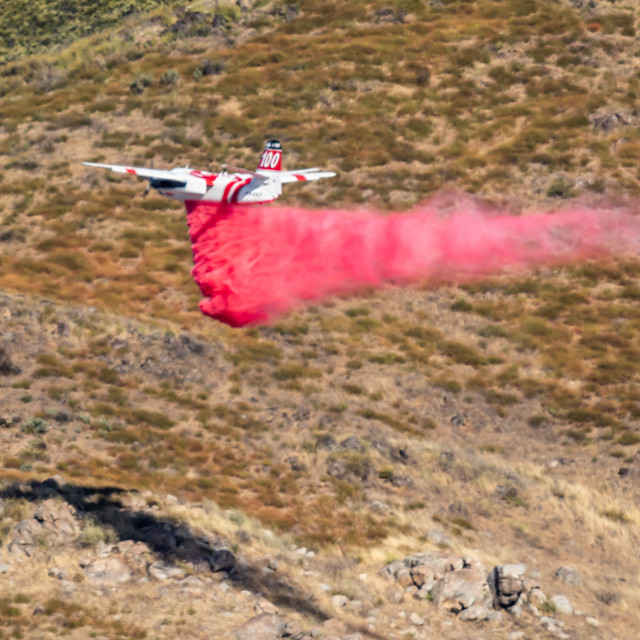 "Winchester, CA USA - June 14, 2020: Cal Fire aircraft drops fire retardant on..." stock image
