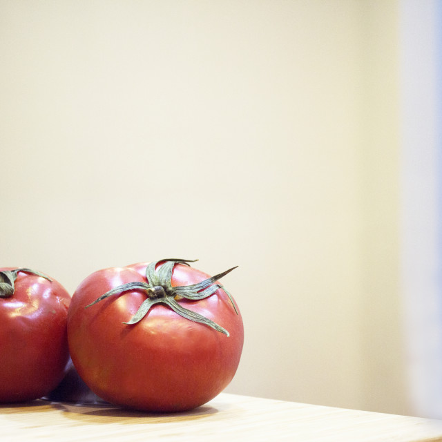 "Two red ripe tomatoes on wooden cutting board" stock image