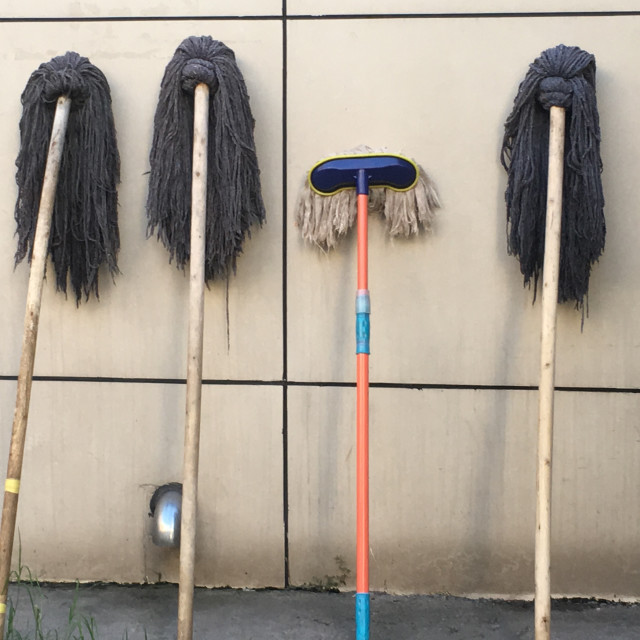 "Mops lined up outisde a building in Beijing" stock image