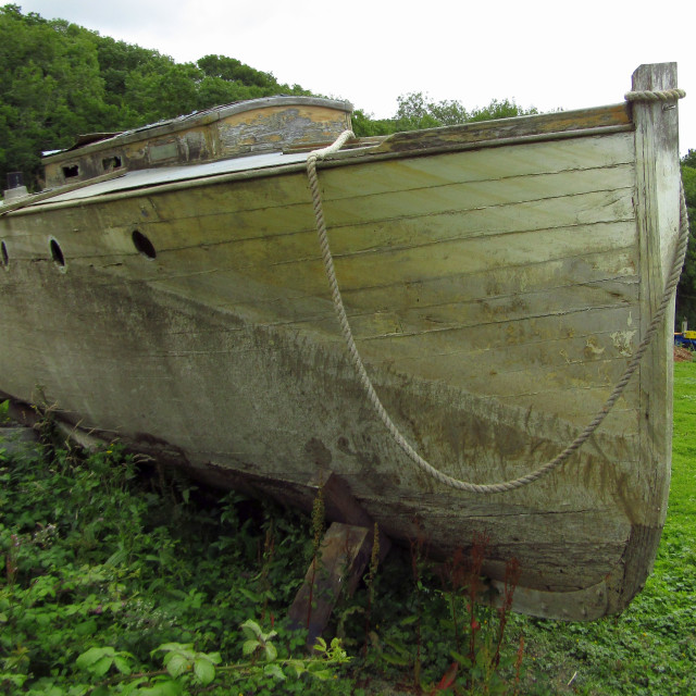 "Derelict wooden boat in field" stock image