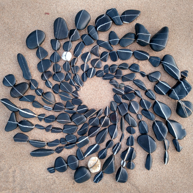 "A Vortex circle spiral made from stones on beach sand" stock image