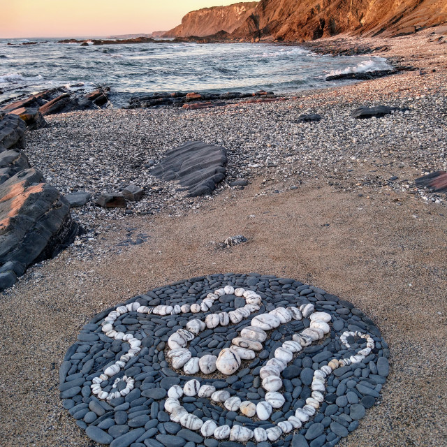 "White stone serpent in a dark pebble circle" stock image