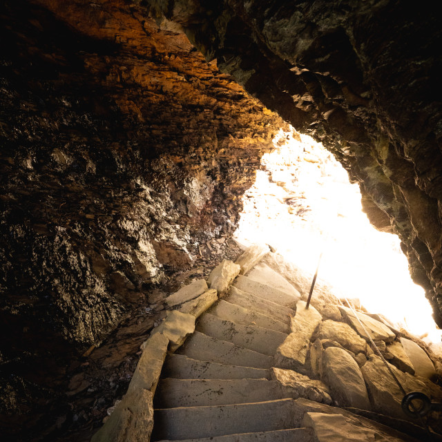 "trail stairs down through a cave archway into the sun" by Justin Mueller - £10.00 "trail stairs down through a cave archway into the sun" stock image