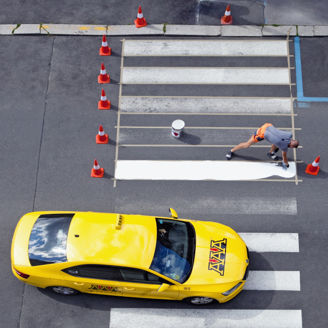 "Workers painting crosswalk stripes with white colour." stock image