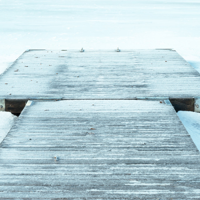 "Wooden jetty in frozen lake" stock image