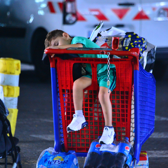"A kid falling asleep in the shopping cart" by Amit Mendelsohn - £50.00 "A kid falling asleep in the shopping cart" stock image