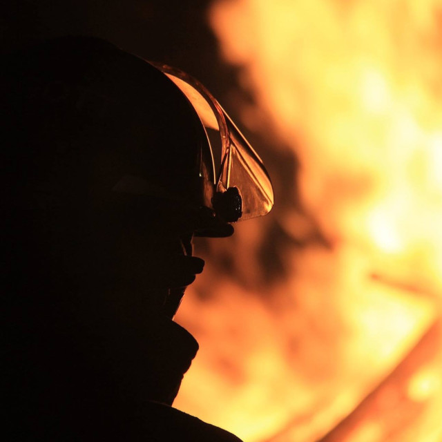 "Firefighter watching a bonfire" stock image