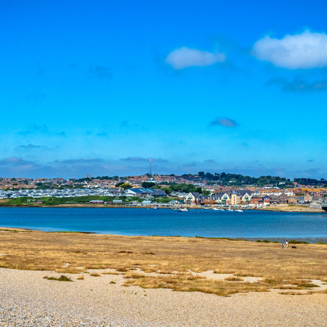 "View of Fleet lagoon from Chesil beach with the village of Wyke Regis in the distance, Dorset, England, UK. Fleet lagoon lies between Chesil Beach, and the mainland Dorset shore, just west of Weymouth and the Isle of Portland. It is thought to be one of t" stock image