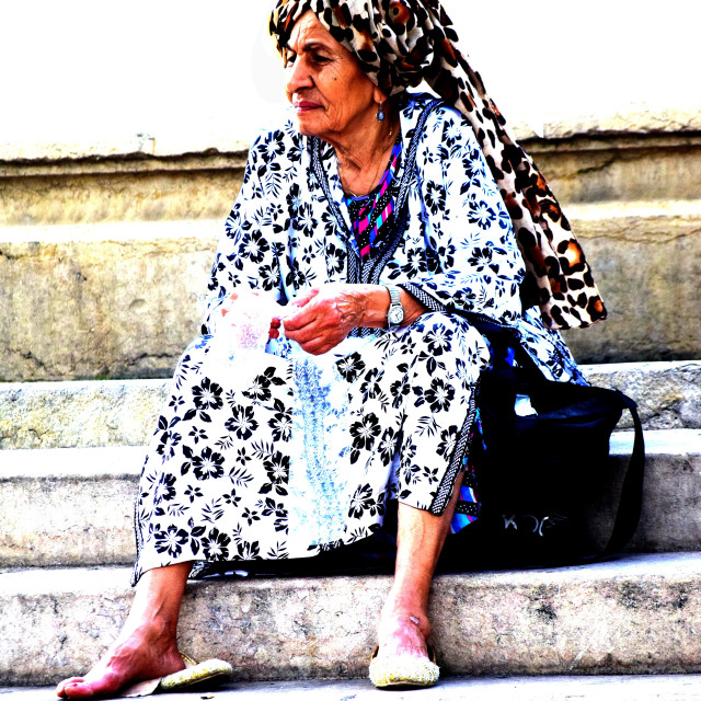 "An old woman by the fountain" stock image