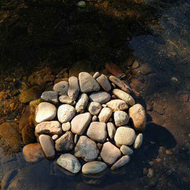 "Landart stone pebble circle moon in river" stock image