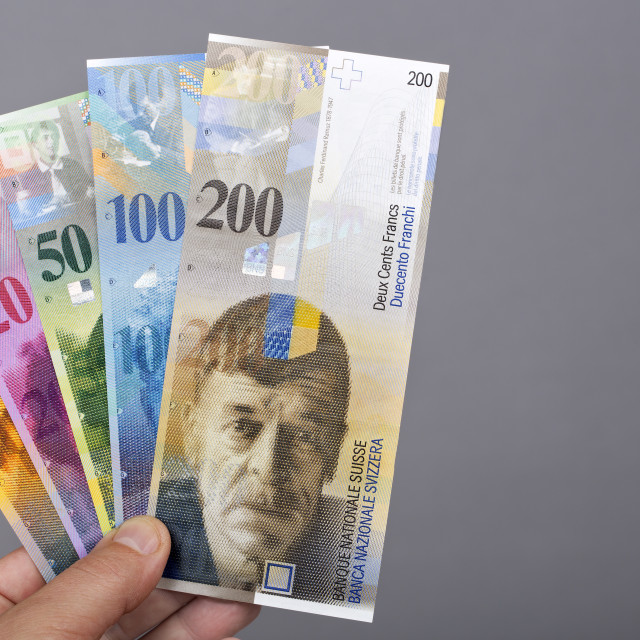 "Swiss franc in the hand on a gray background" stock image
