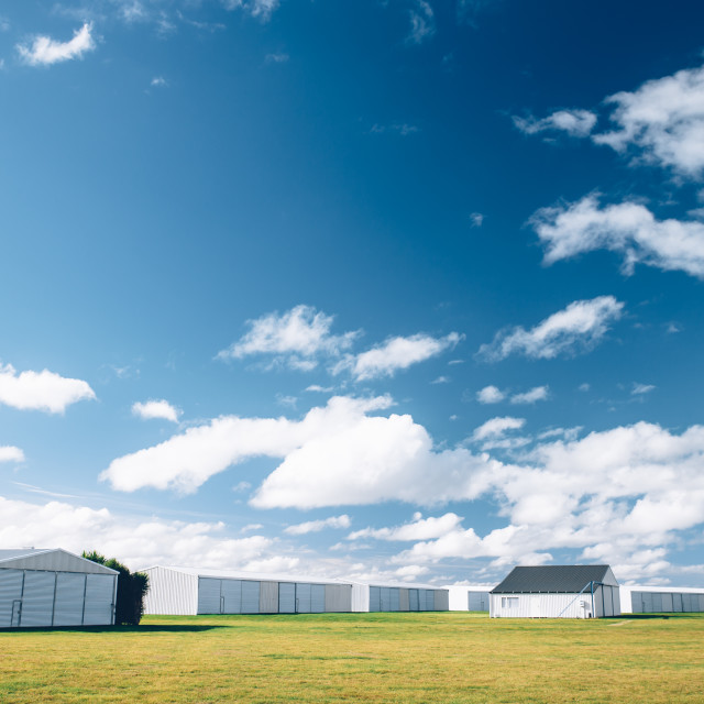 "Steel barn on a farm with cloudy blue sky." stock image