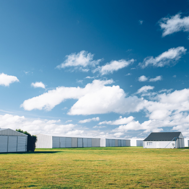 "Steel barn on a farm with cloudy blue sky." stock image