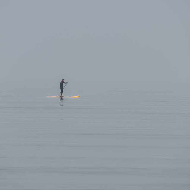 "A man on a paddle board in still waters in the mist of the Firth of Forth" stock image