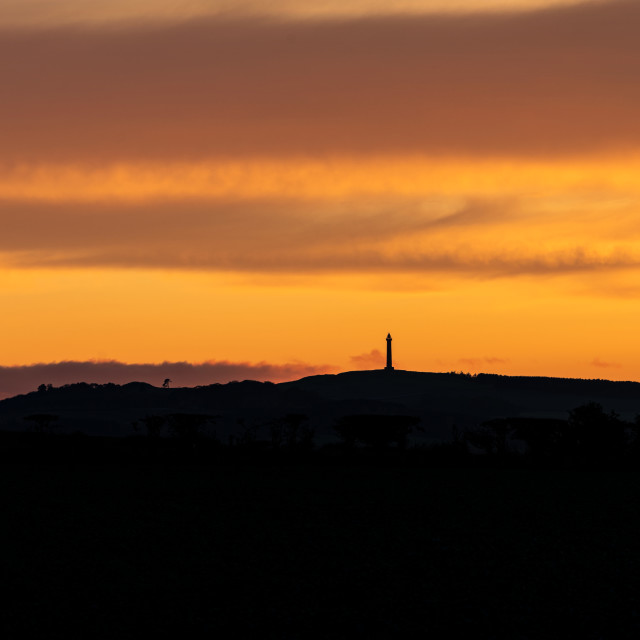 "Scottish Borders at sunset with the Waterloo Monument in silhouette, Scottish Borders, UK" stock image