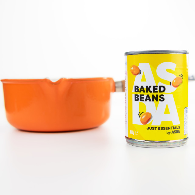 "Asda Essentials Low Priced Baked Beans with an orange Saucepan on a white background" stock image