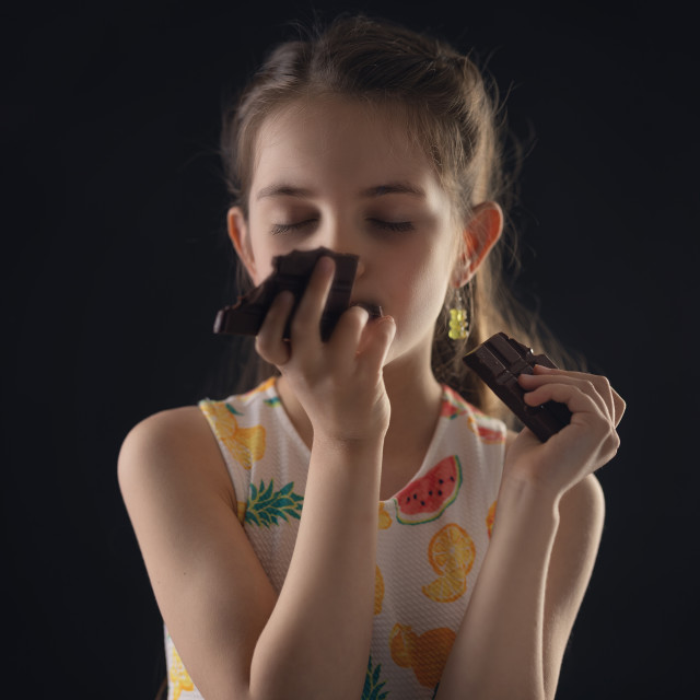 "Chocolate and pretty hungry little woman portrait. Beautiful girl ready to eat chocolate bar." stock image