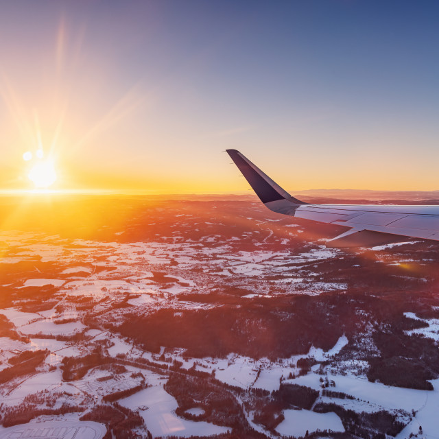 "Airplane flying low over snowy mountains and preparing for landing to the airport, view from plane window of wing turbine and skyline" stock image