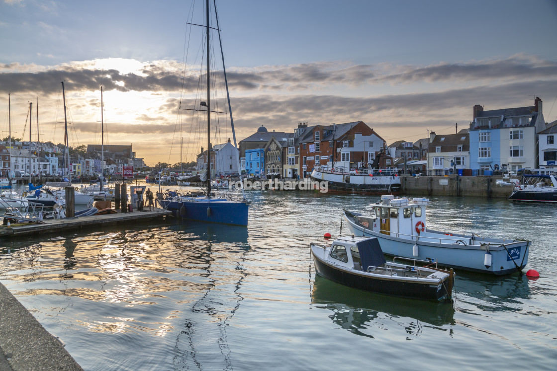 "View of boats in the Old Harbour and quayside houses at sunset, Weymouth,..." by robertharding - $62.60 "View of boats in the Old Harbour and quayside houses at sunset, Weymouth,..." stock image
