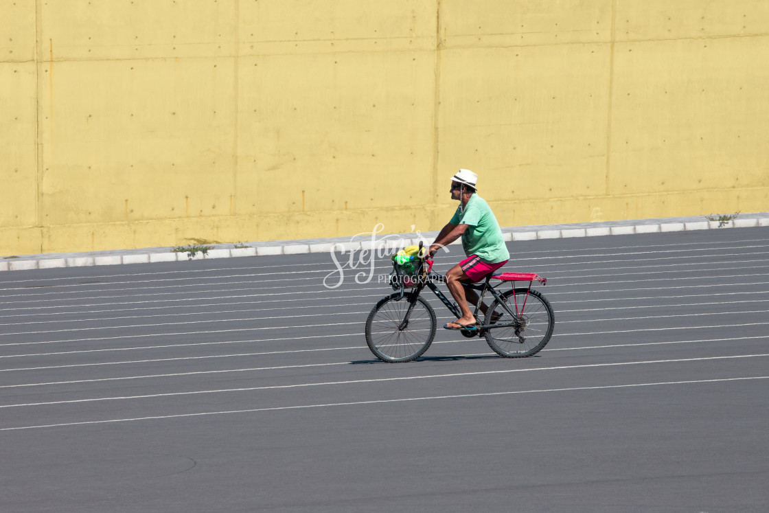 "Man on bicycle in front of concrete wall in yellow" by Stefan Schweihofer - £10.00 "Man on bicycle in front of concrete wall in yellow" stock image