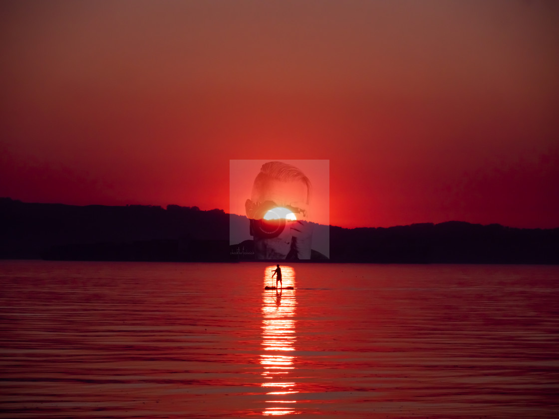 "Stand-Up Paddler Crossing the Sunset" stock image