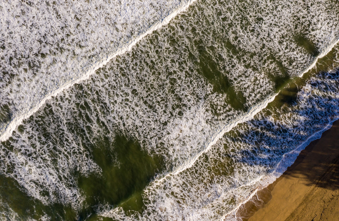 "Vertical top down view of waves crashing towards the beach in Hanalei on Kauai" stock image