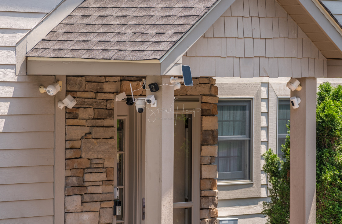 "Multiple cameras and sensors securing front door of home" stock image