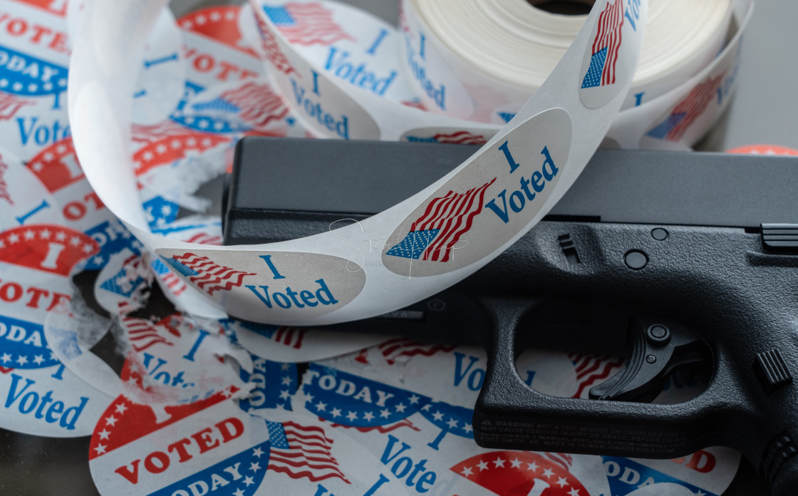 "Many torn voting campaign buttons with handgun as concept for for voter..." stock image