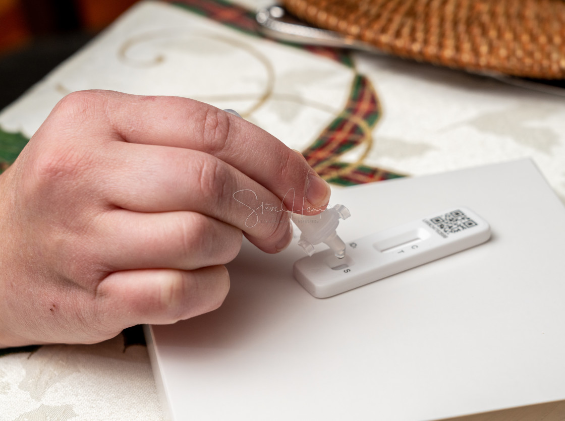 "Self-test kit for Covid-19 with buffer solution being dripped onto test strip" stock image