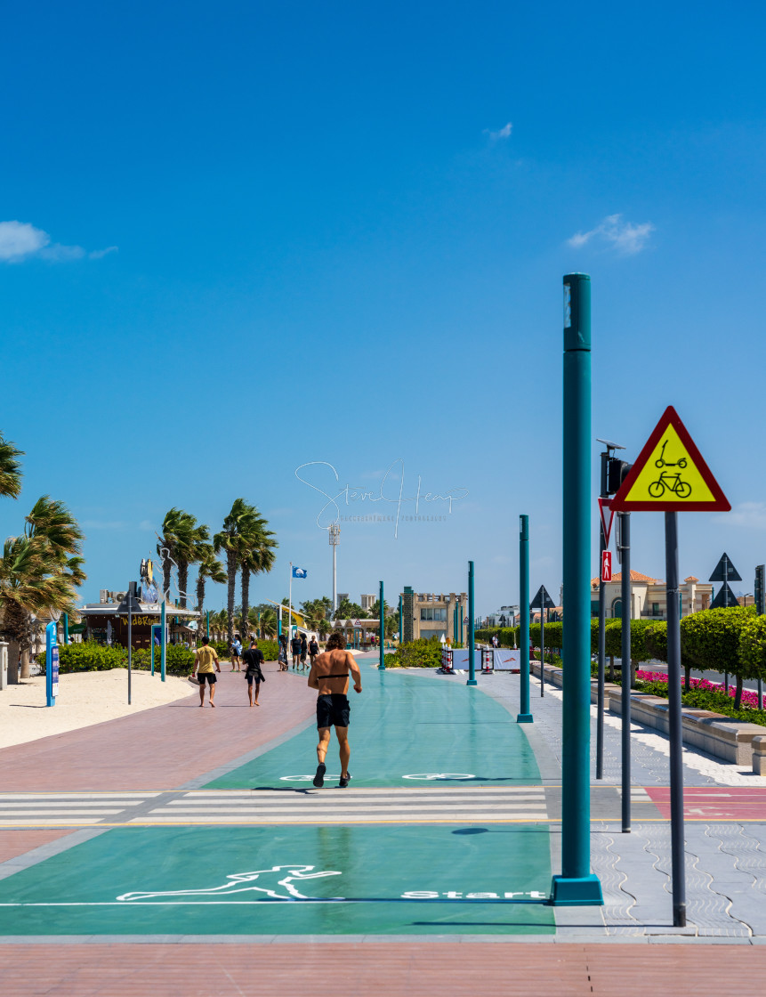 "Man starting to jog along the running track alongside Dubai beach" stock image