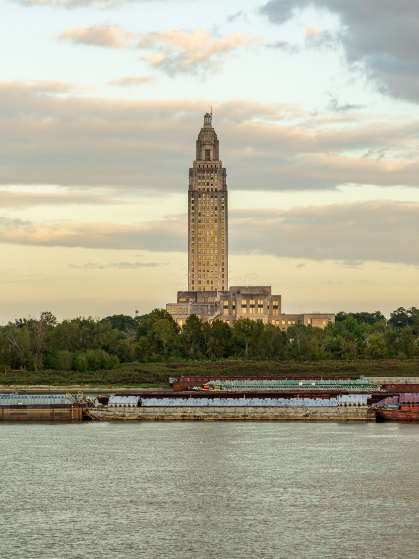 "Skyline of Baton Rouge at sunset over river barges" stock image