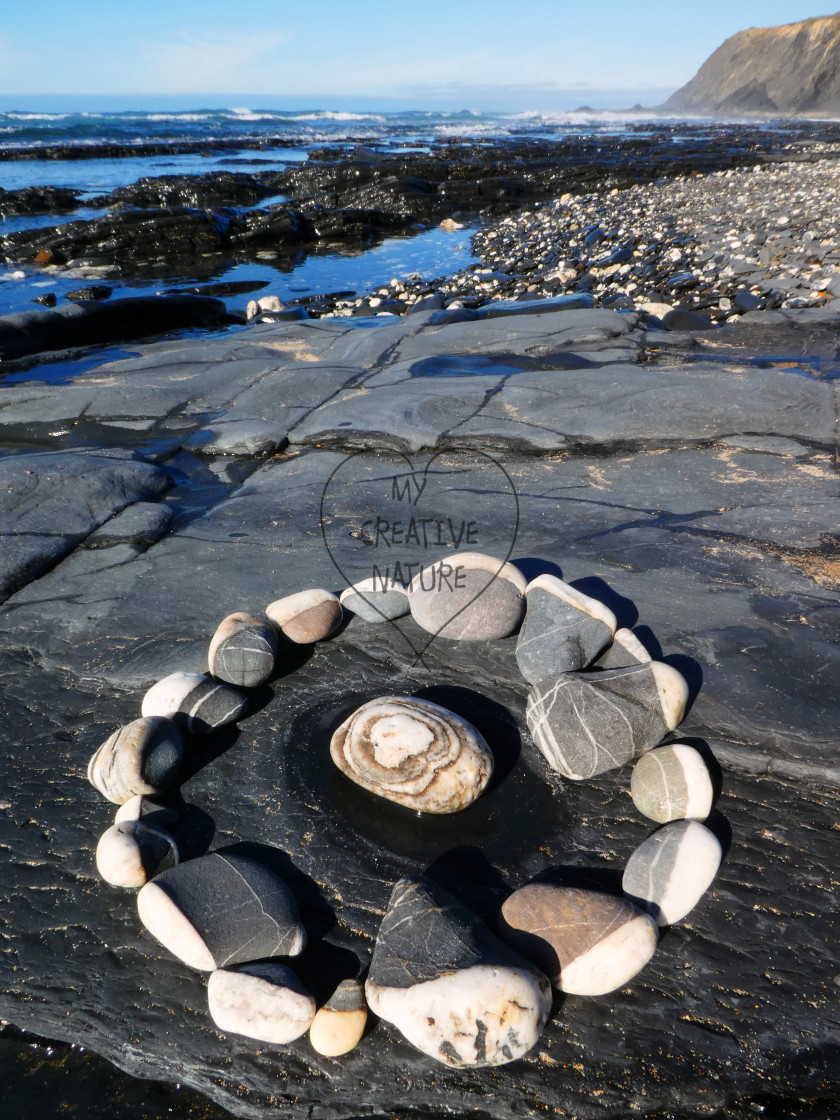 "pebble circle on a beach rock" stock image