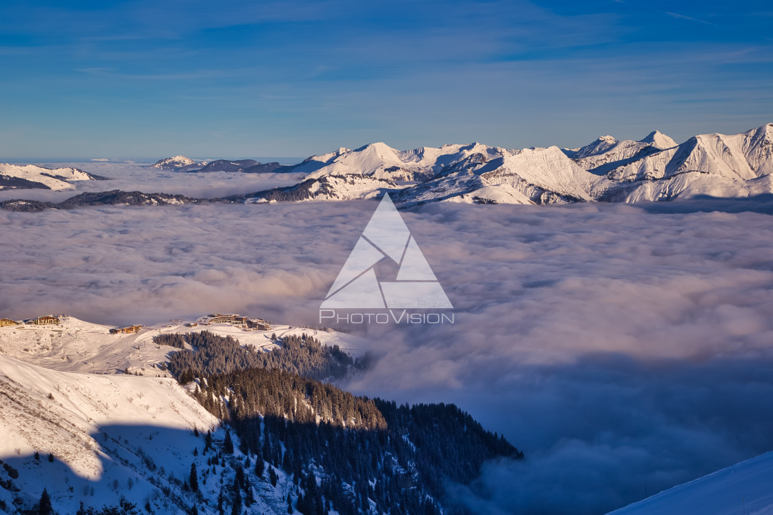 "Inversion in valley and illuminated mountain peaks" stock image